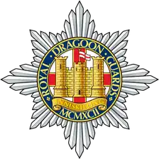 Royal Dragoon Guards cap badge: silver star with the gilt Inniskilling castle on a blue circlet.