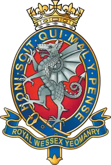 Cap badge: silver wyvern on a red oval in a blue garter lettered HONI SOIT QUI MAL Y PENSE, crown above.